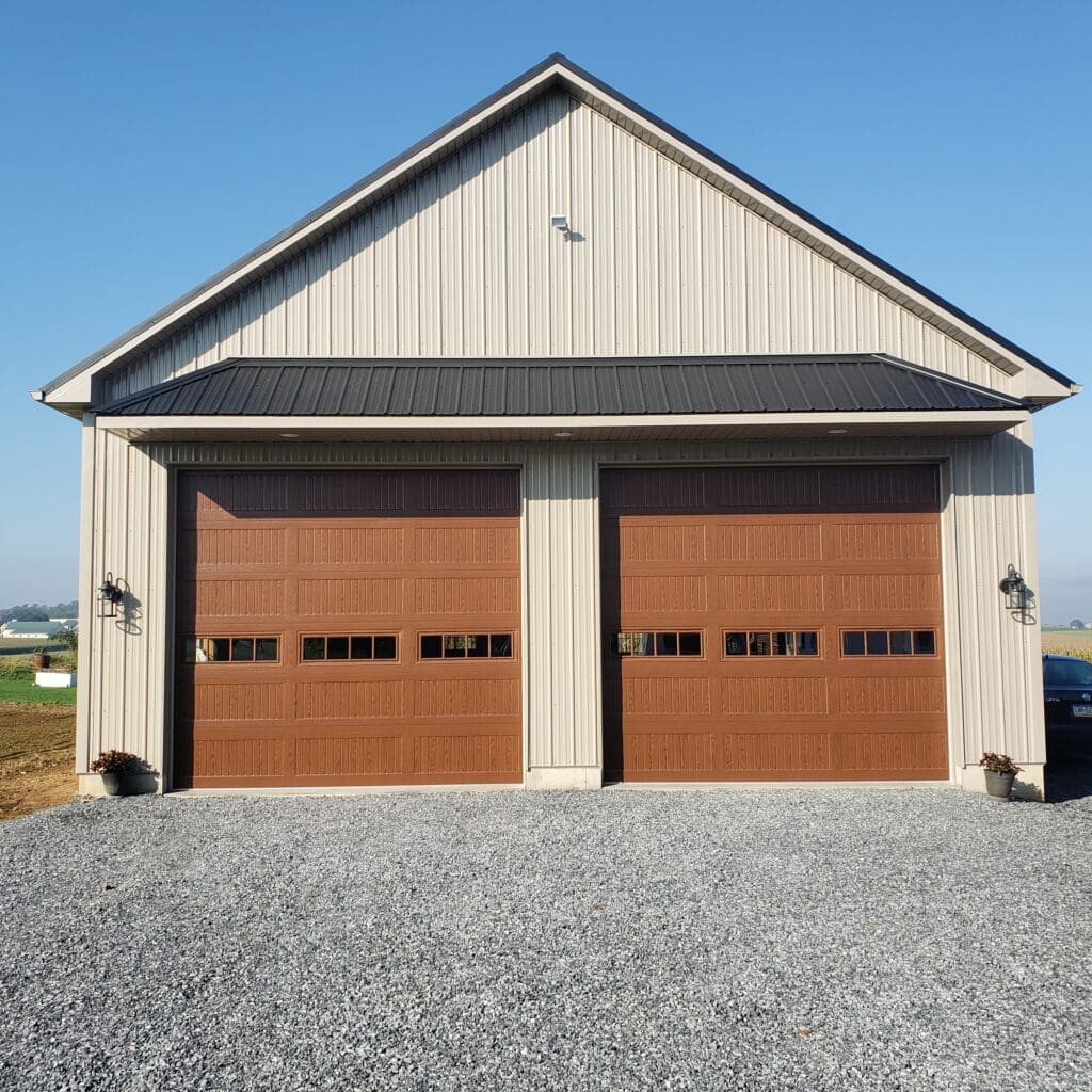 A garage with two doors and a gravel driveway.