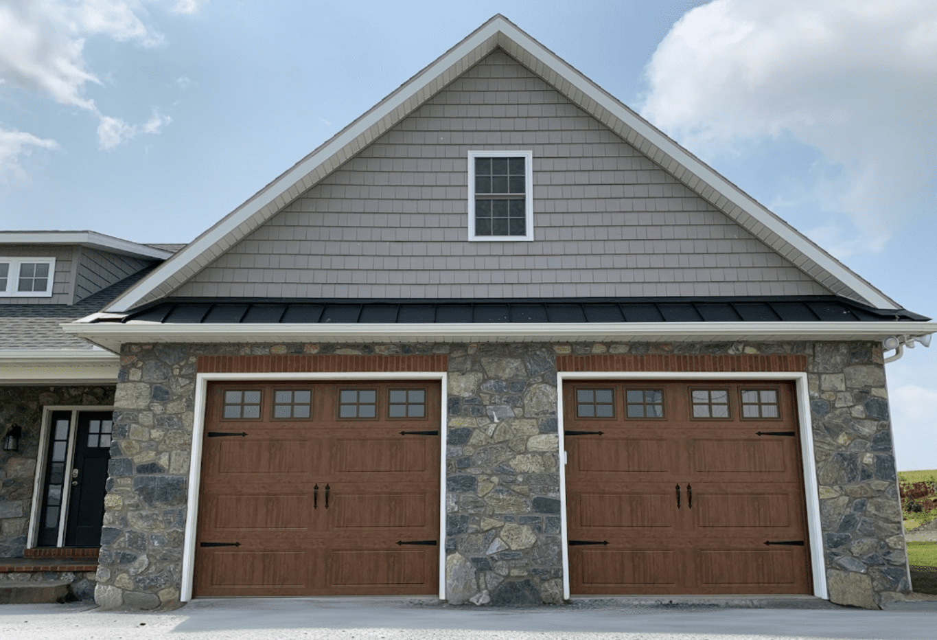 A home with two garage doors and a stone front.