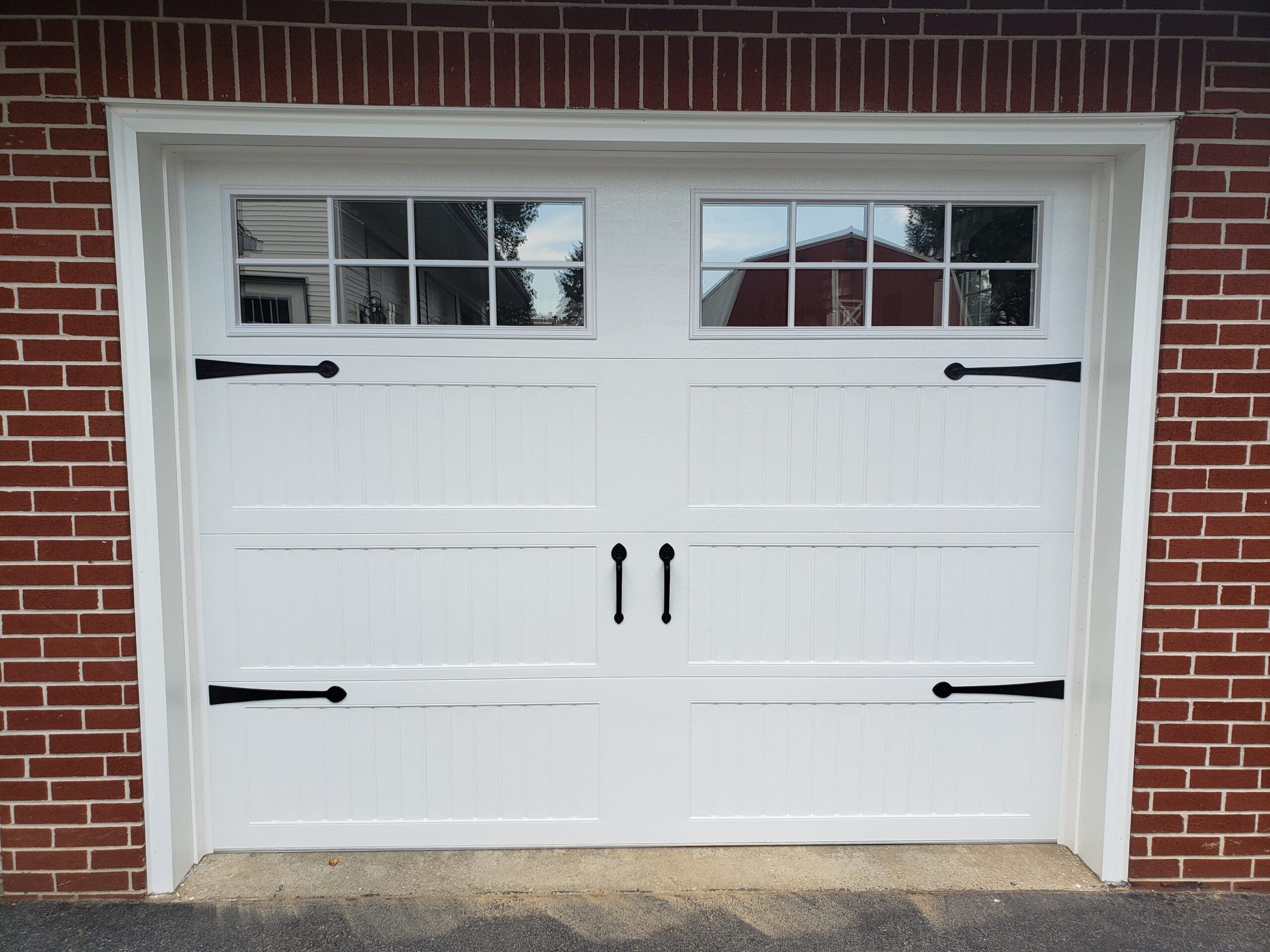 A white garage door with black handles.